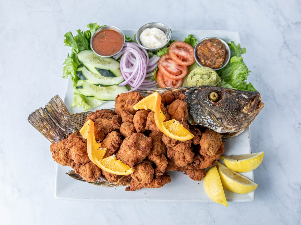 A whole red snapper fried chicharrón style with salsas and fresh garnishes.