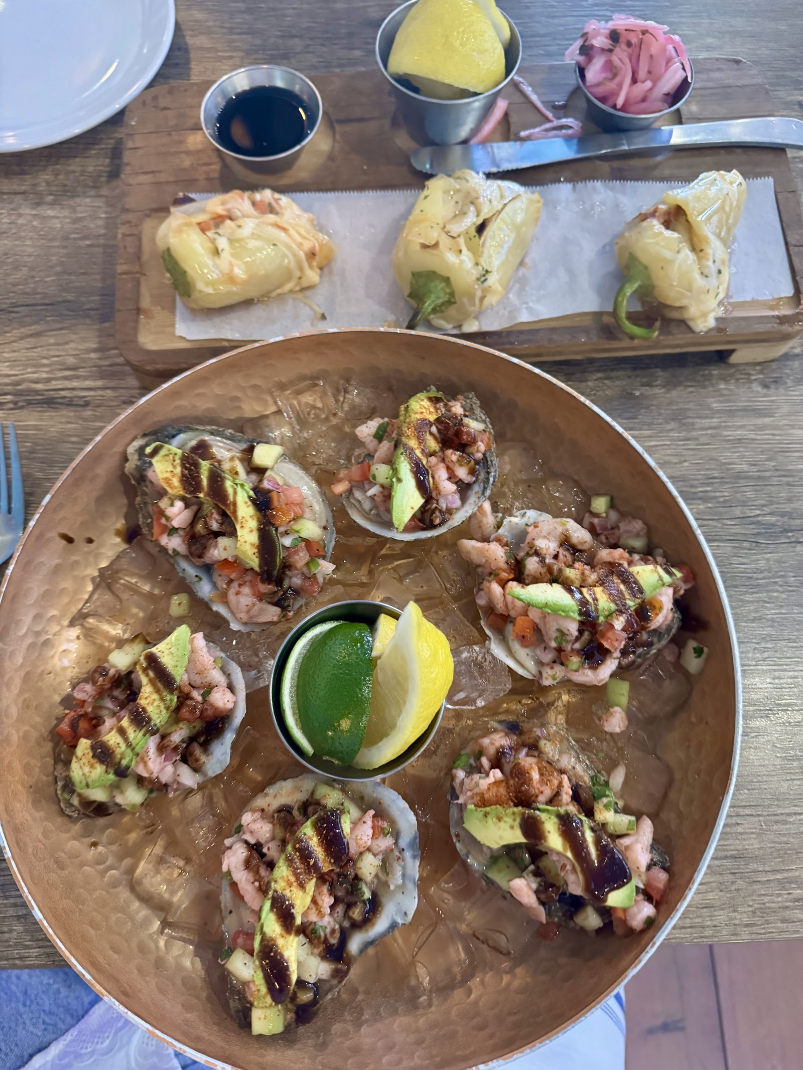 Half-shell oysters topped with shrimp ceviche, avocado and chile.
